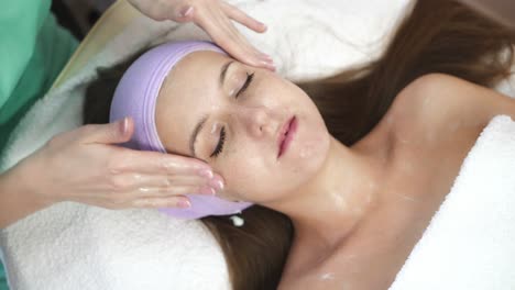 facial massage by therapist. lovely woman enjoying massage treatment by therapist in spa salon