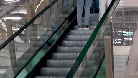 two people riding up an escalator in a building