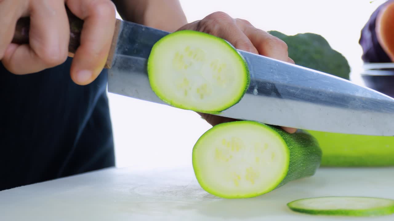 4k 여성 손으로 는 보드에 신선한 zucchini를 잘라 여성 손은 기 보드에 칼로 원시 일본 호박을 어서 원형으로 잘라 건강한 음식 개념 카메라 움직임 기술