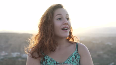 smiling woman with red hair at sunset