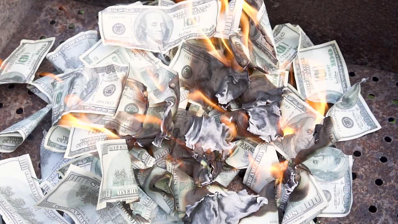Counterfeit money. Slow motion of dollars money on fire lost money. Financial disaster concept