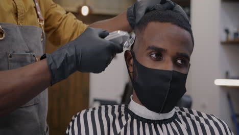 man getting a haircut at a barber shop during covid-19