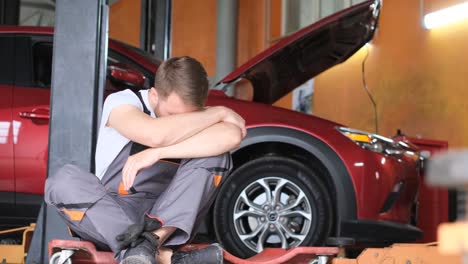 frustrated mechanic experiencing problems in a car repair shop