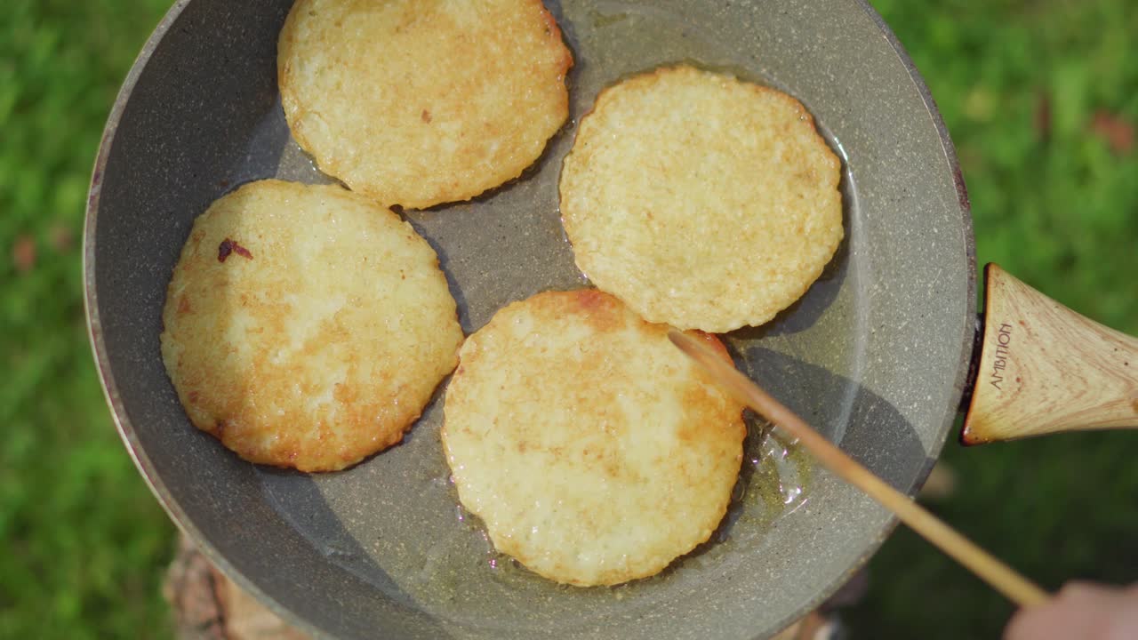 Yazın dışarıda, tavada yağda kızaran patates mücverleri.