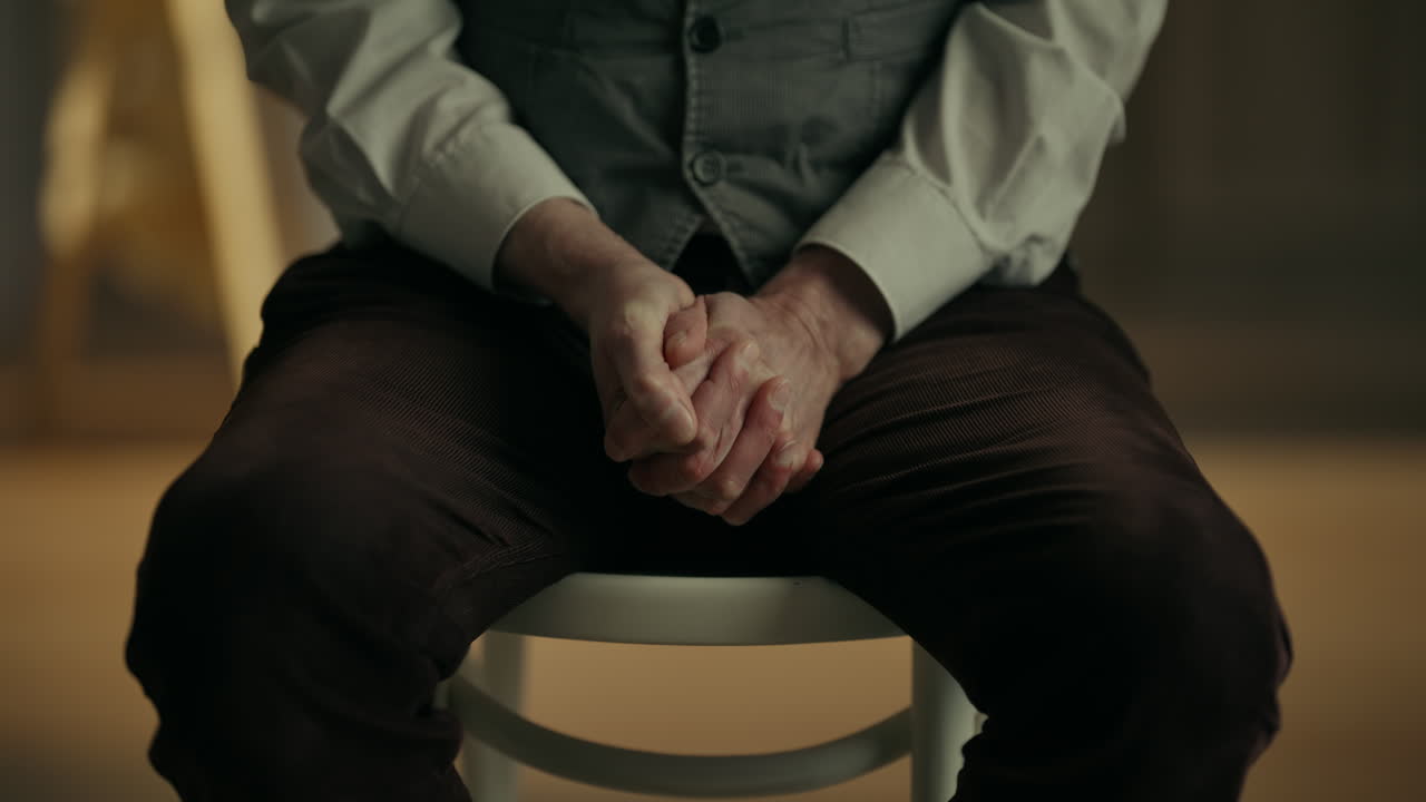 Primo piano di una persona nervosa che si agita le mani mentre è seduta
