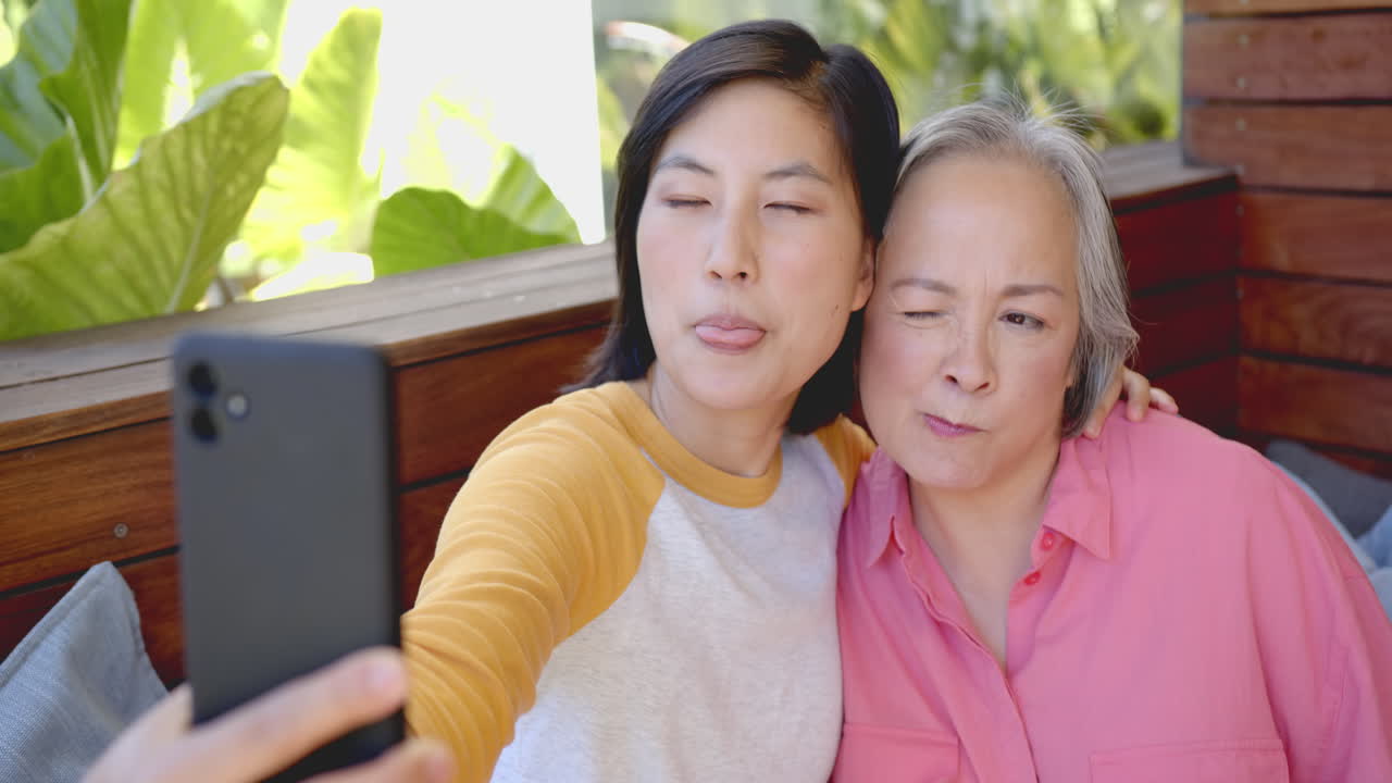 Taking selfie, women smiling and making funny faces, enjoying time together
