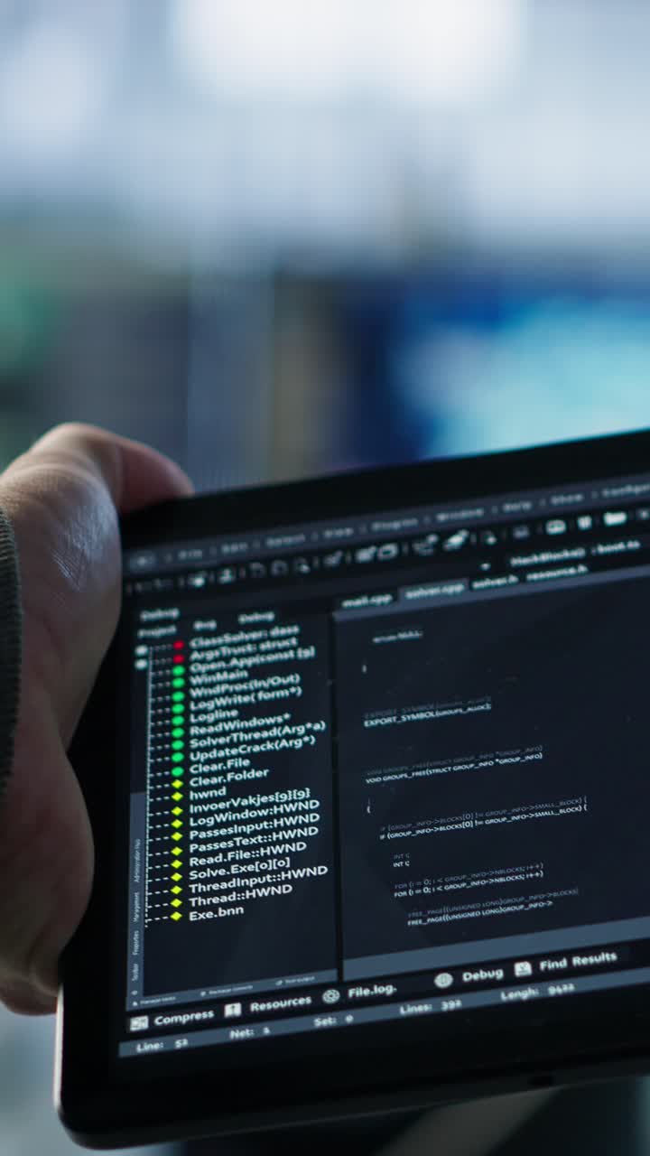 Developer's Hand Holding Tablet Showing Programming Code