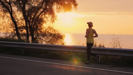 Woman-Makes-An-Evening-Jog-Along-The-Road-Along-The-Lake-Steadicam-Follow-Shot