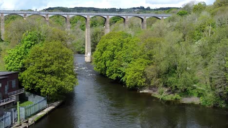 aerial view pontcysyllte aqueduct and river dee canal narrow boat bride in chirk welsh valley countryside slow push in