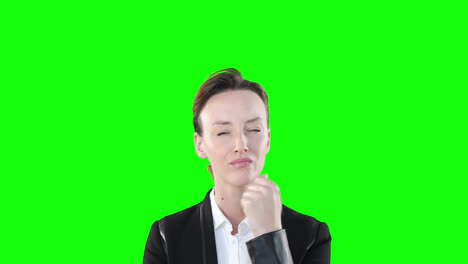 skeptical caucasian woman looking at camera on green background.