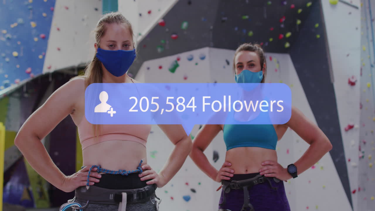 анимация медиа-иконы над двумя кавказскими женщинами с масками на стене для скалолазания