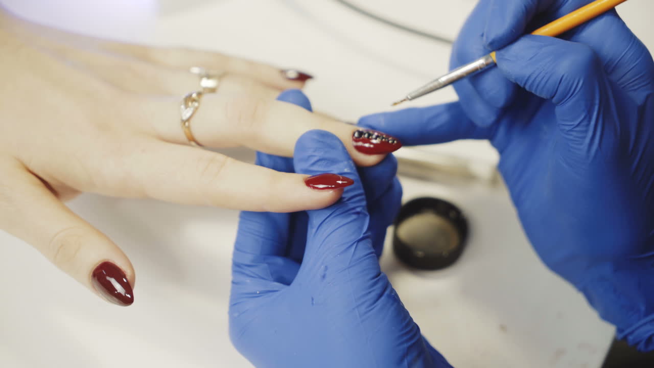 Manicure concept. Girl paint nails in the salon of manicure, close-up