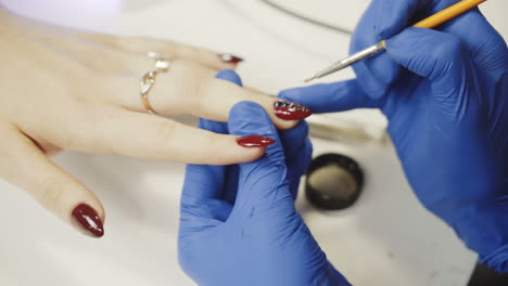 manicure concept. girl paint nails in the salon of manicure, close-up