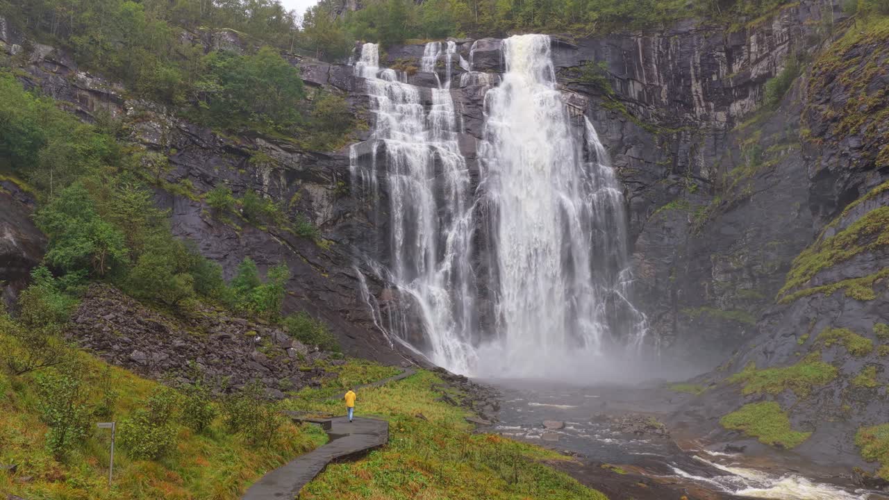 Veduta aerea con drone sulle cascate di Skjervefossen con un uomo in piedi accanto in Norvegia