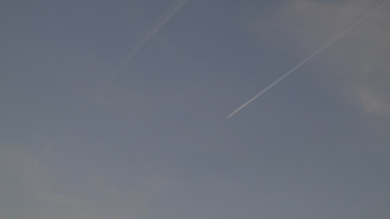 Sky with contrails from passing airplanes, clear weather and calm atmosphere