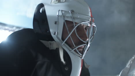 primo piano di una rete di difesa concentrata del portiere di hockey maschile durante una partita sull'arena del ghiaccio