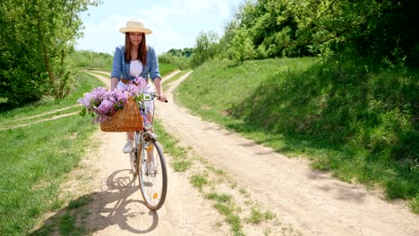 cute girl in a hat on a bicycle traveling in nature