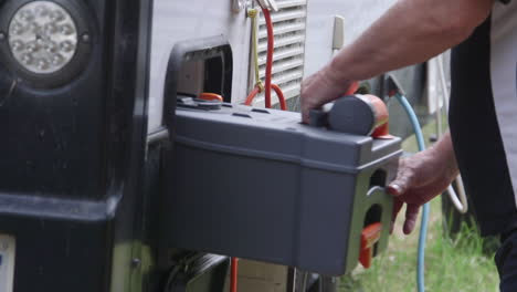 opening the chemical toilet hatch and removing the canister to be emptied from an rv caravan while holidaying