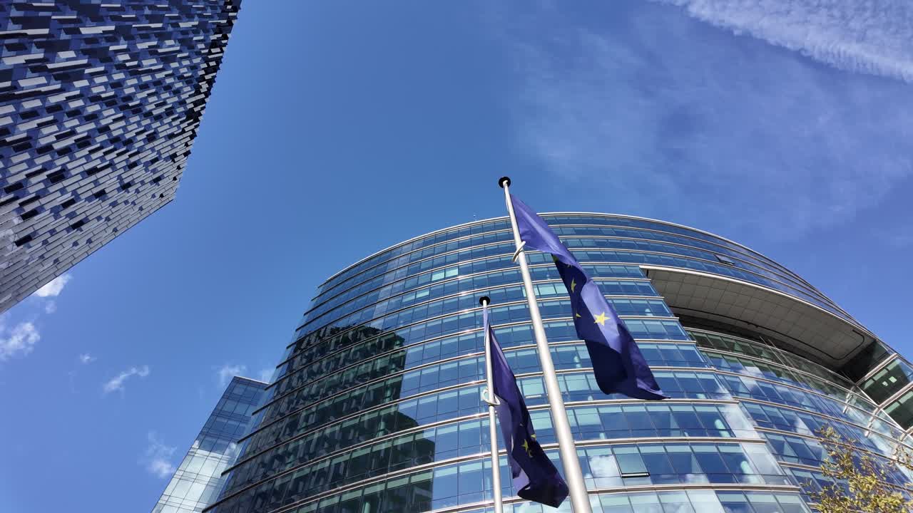 Bandiere dell'UE che sventolano di fronte alla facciata in vetro del Lex Building a Bruxelles