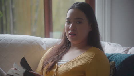 portrait of a woman reading bible inside her bedroom