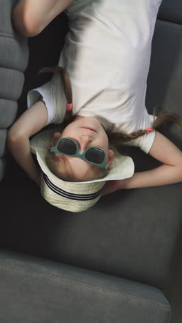 little boy plays with aeroplane toy near suitcase while elder sister relaxing on sofa. happy kids spend time in hotel after arrival upper close view