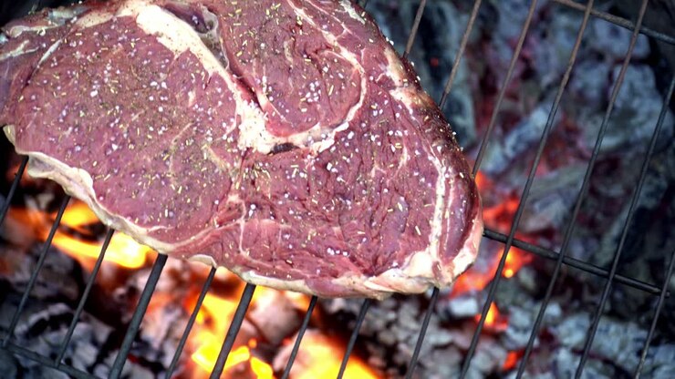 Steak sapi dimasak di atas panggangan.