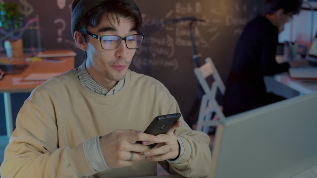 Young man working on his phone in a modern office