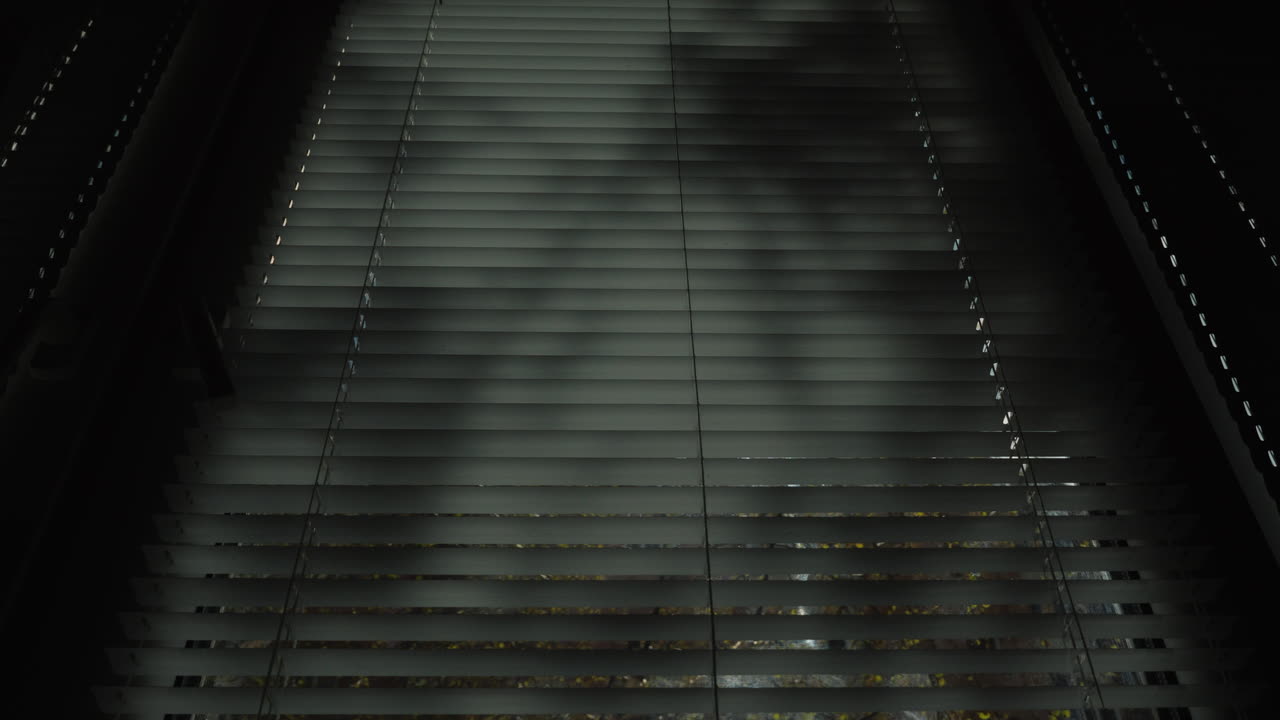반쯤 닫힌 jalousie 4k 비디오를 통해 봄 햇살이 빛납니다.