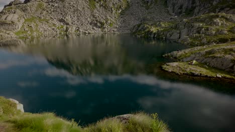 Scenic-reflection-of-mountains-and-clouds-in-small-lake-in-Italy