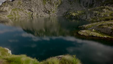 reflejo escénico de montañas y nubes en un pequeño lago en italia