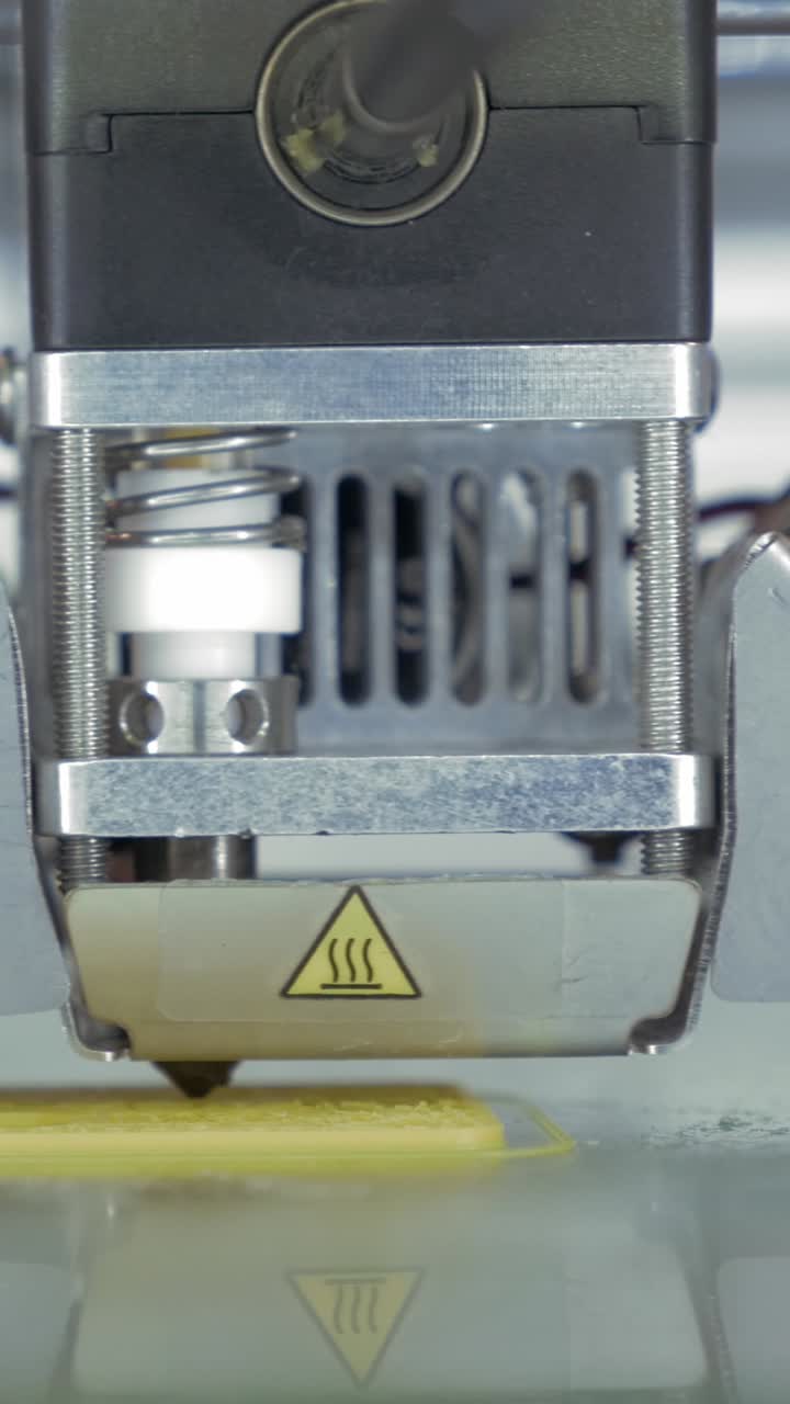 Close-up of 3D Printer Nozzle Extruding Yellow Filament