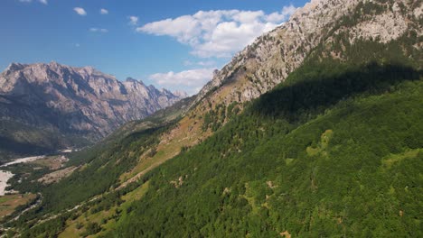 panoramic flight over beautiful valley of valbona in albanian alps with green forestry and sharp mountains