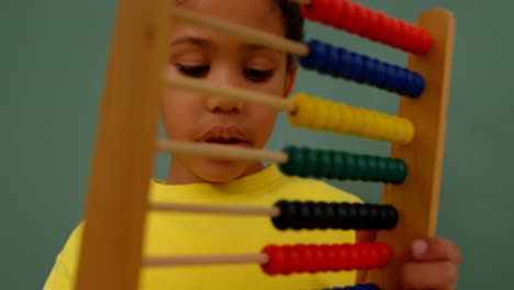 Vista-Frontal-De-Un-Colegial-Afroamericano-Aprendiendo-Matemáticas-Con-ábaco-En-Un-Salón-De-Clases-4k