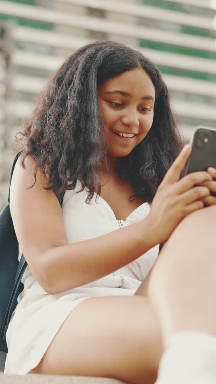 Young woman using her phone outdoors