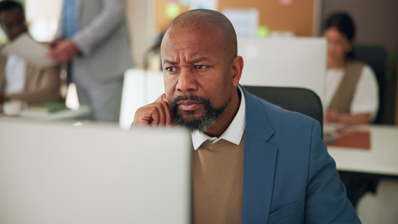 African American Businessman Concentrating on Computer in Office