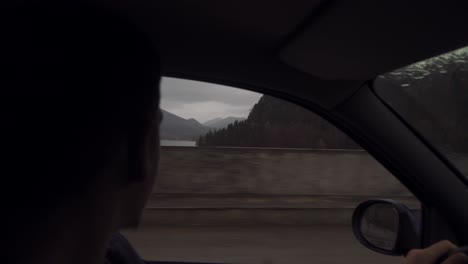 a man travelling driving his car taking a moment looking by his car window the beauty of nature outside on a beautiful day - close up shot