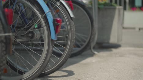 [close up] panning shot of the rear tires of 4 old bikes