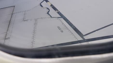 no step warning sign on white airplane wing seen from passenger window