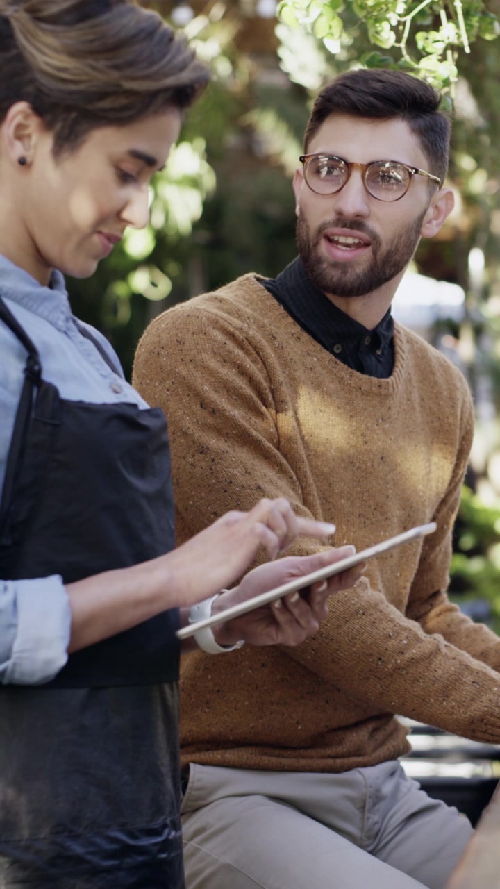 Barista e cliente discutono dell'ordine su tablet al bar