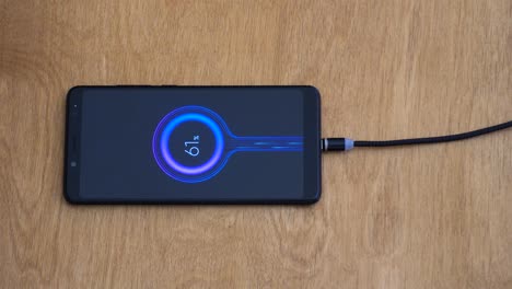 Overhead-close-up-view-of-magnetic-charging-wire-connecting-to-smart-phone