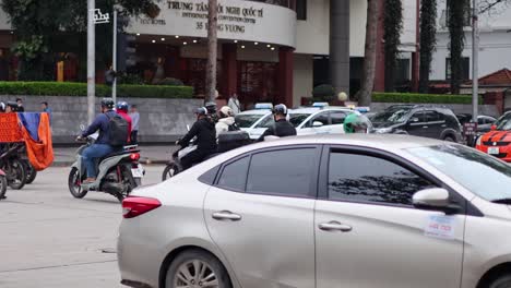 motorbikes and cars navigating busy intersection