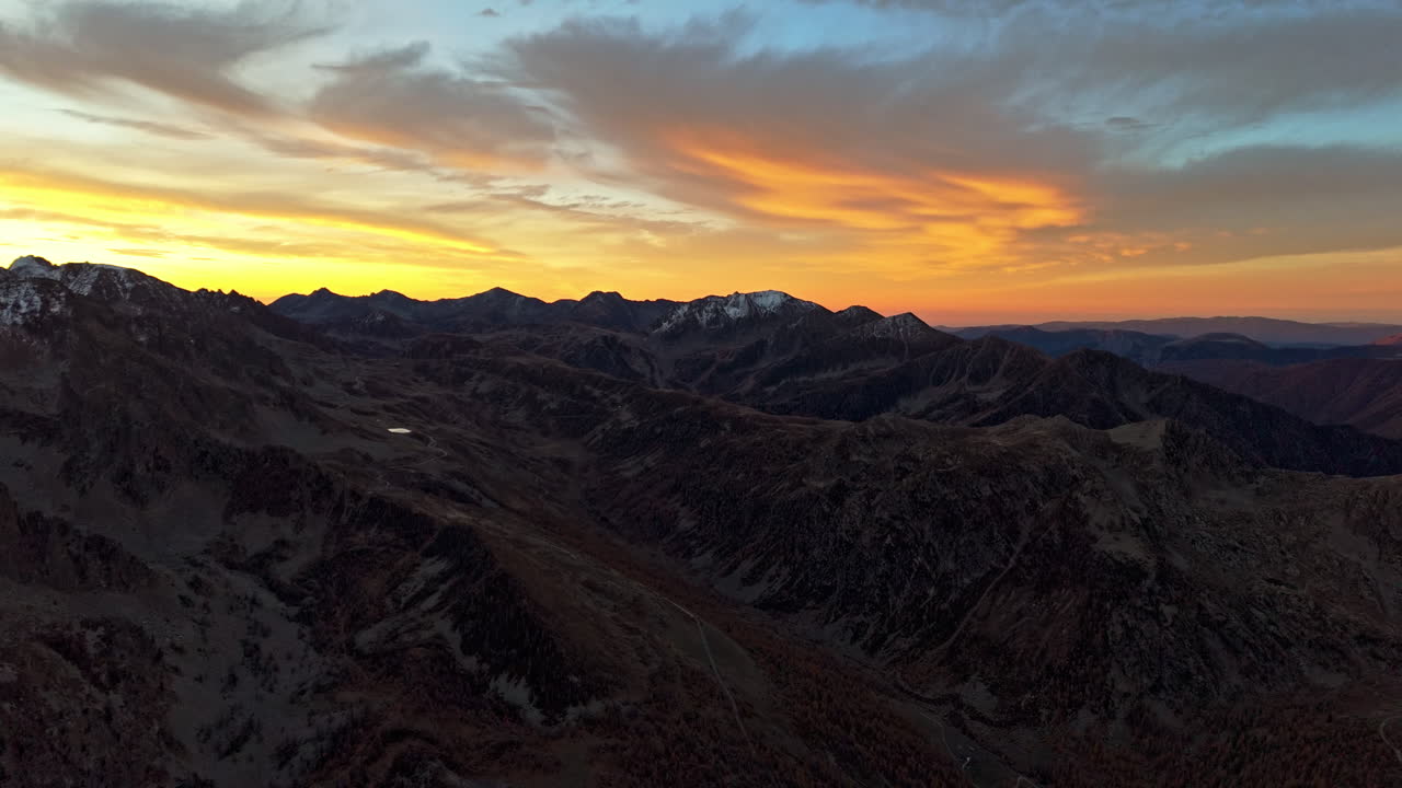 Aerial view of mountains at sunset with vibrant sky and peaks