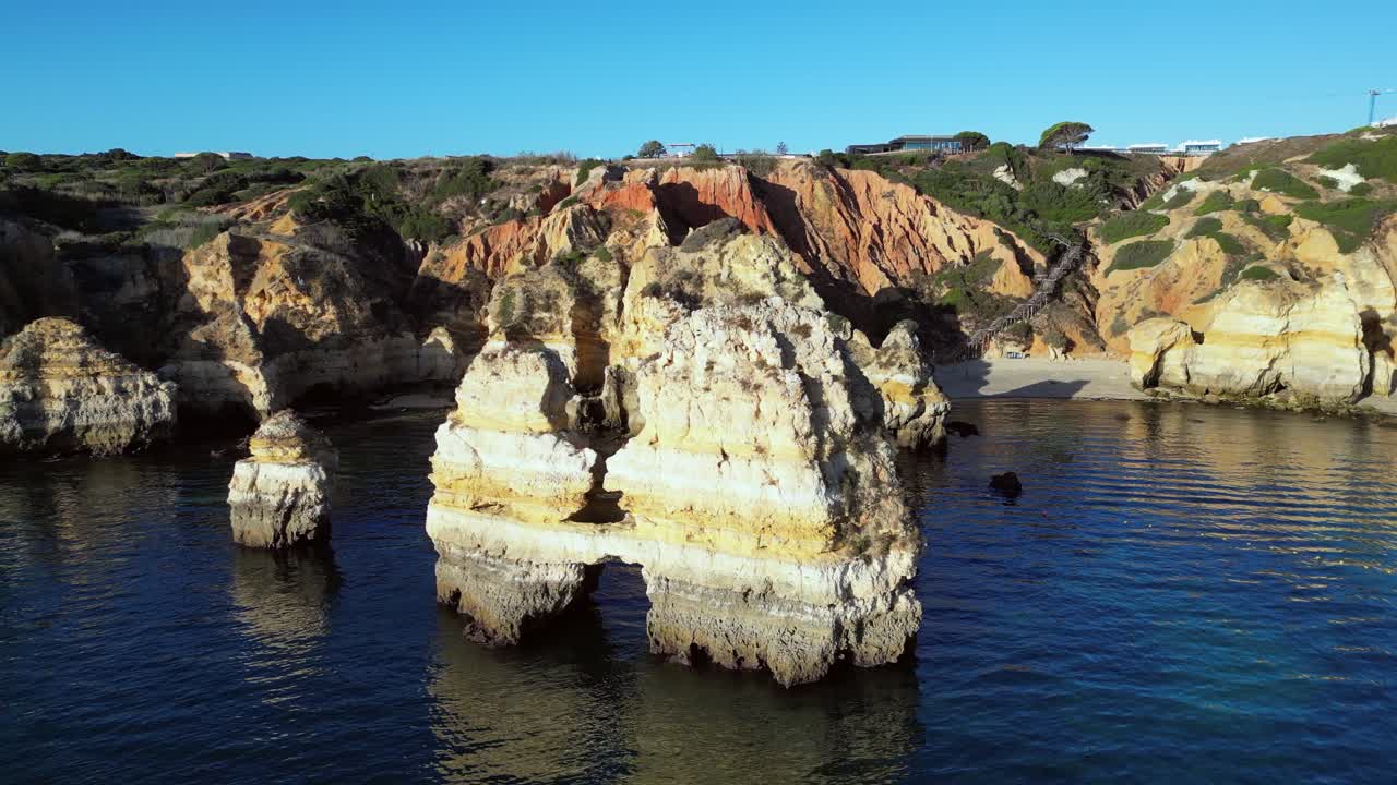 Aerial orbits golden sea stacks on Ponta da Piedade coastline, Portugal