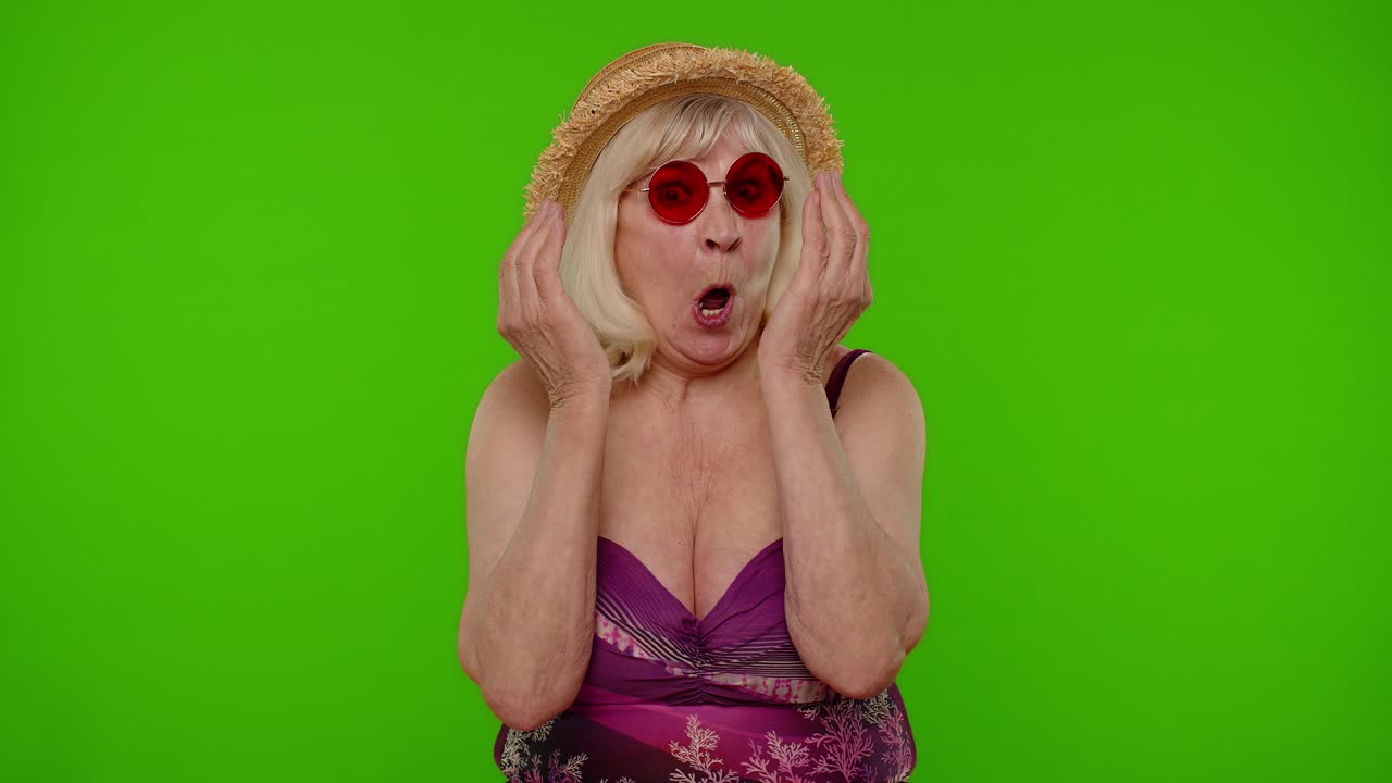 Divertente e spassosa donna anziana turista in costume da bagno, che scherza facendo un'espressione buffa.