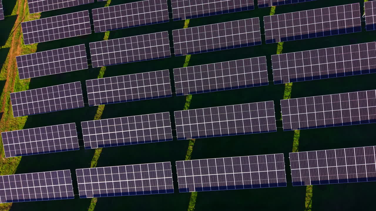 Pannelli solari coprono un vasto campo, catturando la luce solare per un futuro sostenibile in un paesaggio esteso