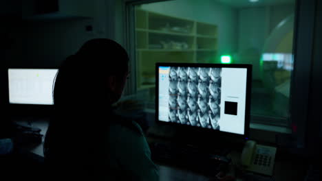 medical worker in front of the monitor. female specialist analyzing patient's results of mri procedure on the screen of a computer in hospital control room.