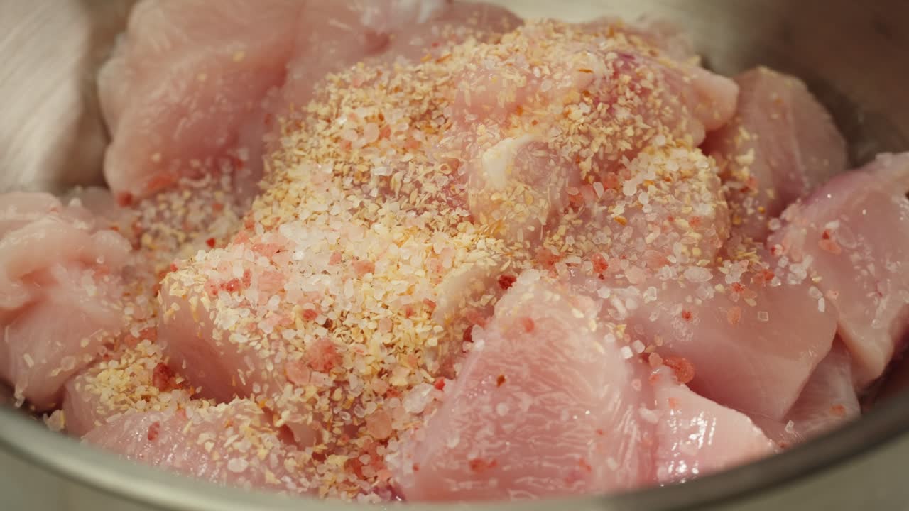 Man slicing raw turkey or chicken meat fillet on oak cutting board closeup, cooking with knife on restaurant kitchen. High quality 4k footage