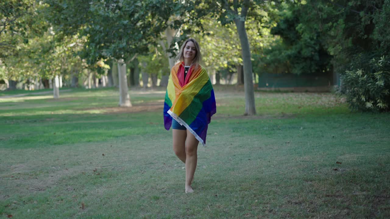 Donna in un parco con una bandiera Pride