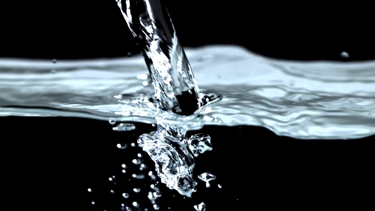 Movimento rallentato di acqua limpida che si versa e schizza su sfondo nero.