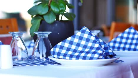 close up of a restaurant table setting with blue and white checkered napkins